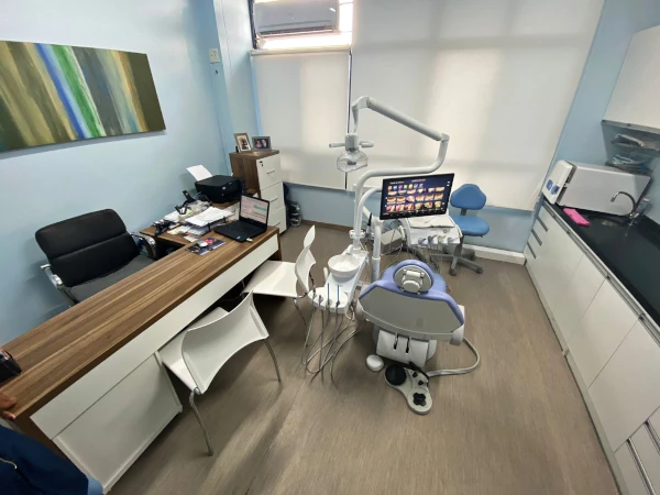 Fotografia de consultório odontológico com mesa e cadeira de dentista.