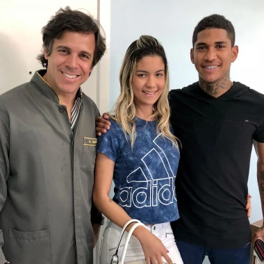 Fotografia do Dr Claudio Costa e com jogador de futebol Raniel e sua esposa